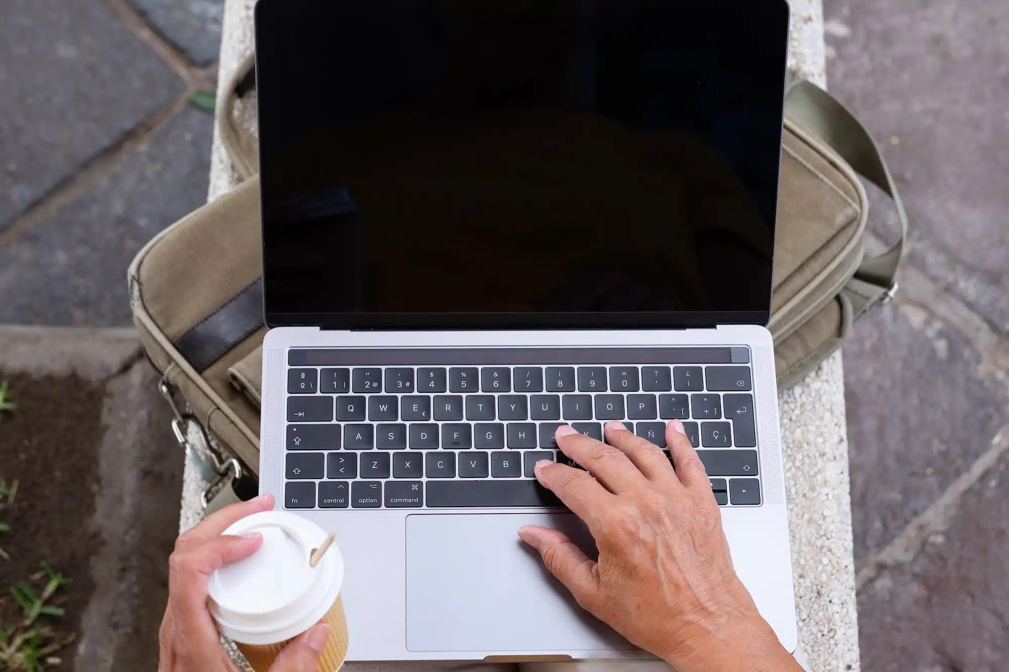 Close up of business woman using a laptop computer on outdoor park. Digital nomadic worker concept